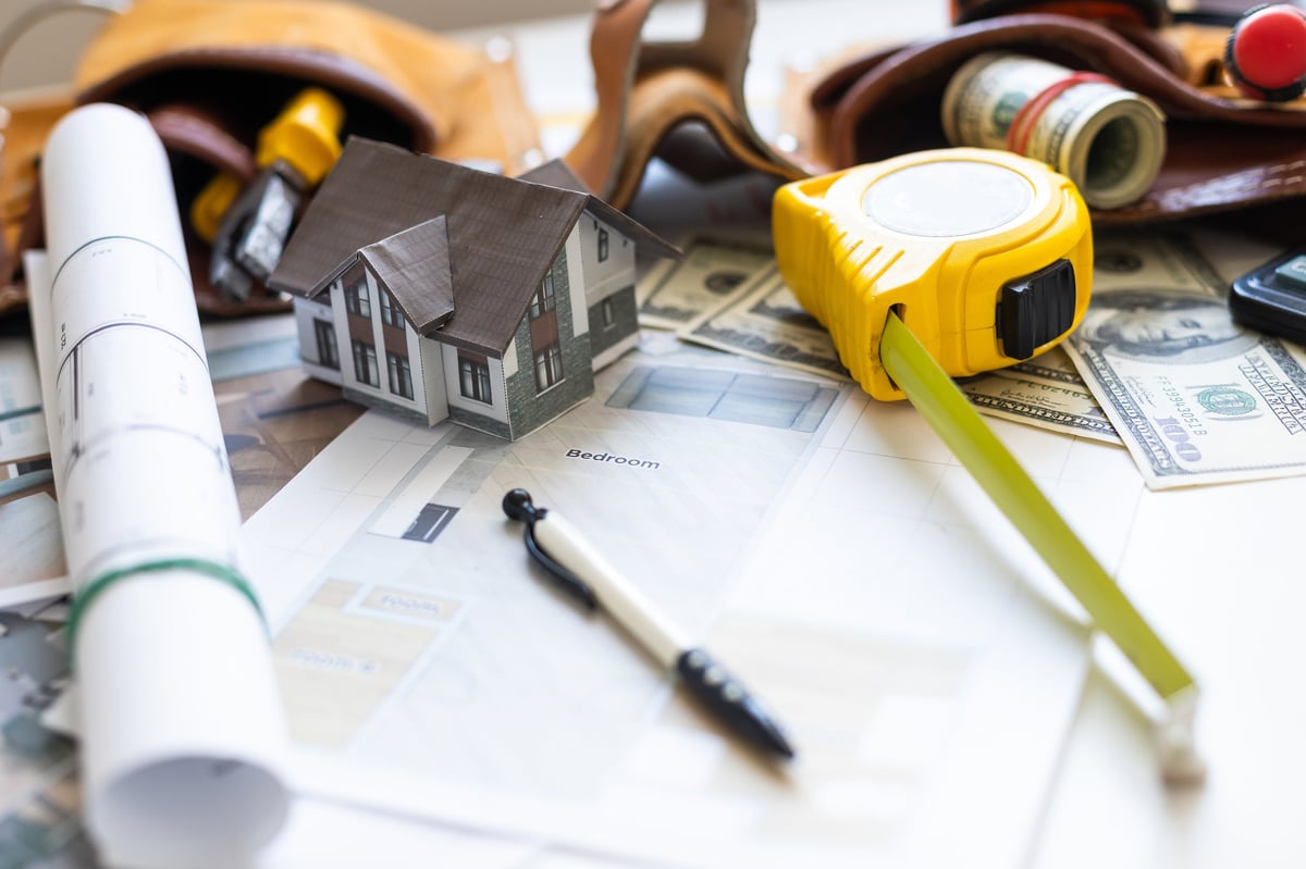 Model house on blueprints with keys to a new home