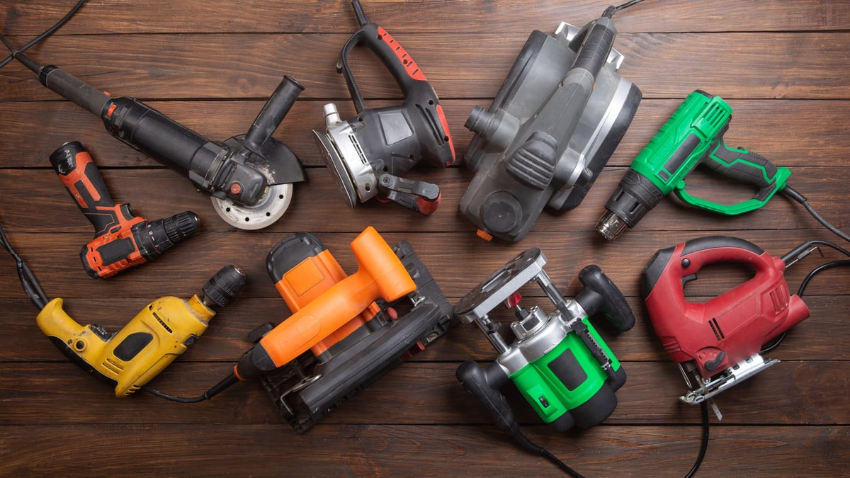 Set of power tools for home repairs laid on a wooden table